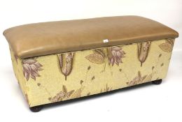 A contemporary upholstered storage unit with padded hinged seat lid.