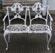 A white painted aluminium two-seater garden bench with foliate decoration.