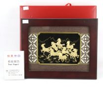 A Chinese gold plated three dimensional image of wild horses.