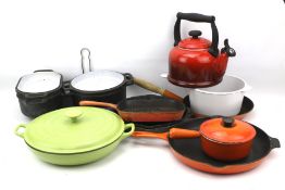 A large assortment of Le Creuset kitchenware and similar wares.