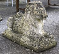 A large stone composite statue of a reclining lion.