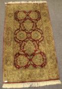 A thick rug with gold flowers on a red ground.