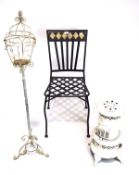 A contemporary metal garden chair, large pricket candle stand and a valor heater.