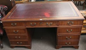 A modern twin pedestal partner's desk with gilt tooled red leather inlay.