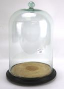 A large glass dome complete with base, probably for a clock.