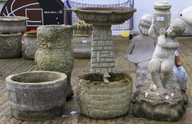 An assortment of stone garden ornaments, pots, and a bird bath.