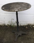 A pub table with round marble top on a cast iron tripod support.