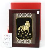 A Chinese gold plated image of a horse.