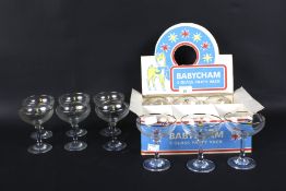 A boxed set of six vintage circa 1970s Babycham glasses and another set of six