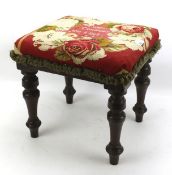 An early 20th century mahogany upholstered footstool on turned supports.