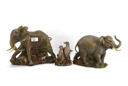 Three contemporary resin animal figures by Ann Richmond of elephants and meerkats.