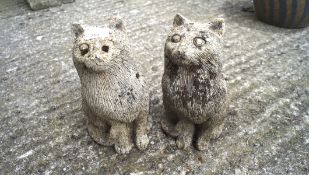 Two stone figures of seated cats.