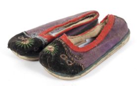 A pair of hand stiched early child's slippers with leather soles