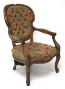 An early 20th century hoop back armchair upholstered in floral textured fabric.