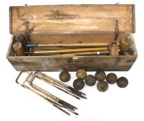 A vintage croquet set in a large wooden box with mallets,