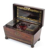 A Regency rosewood and brass inlaid sarcophagus shaped tea caddy.