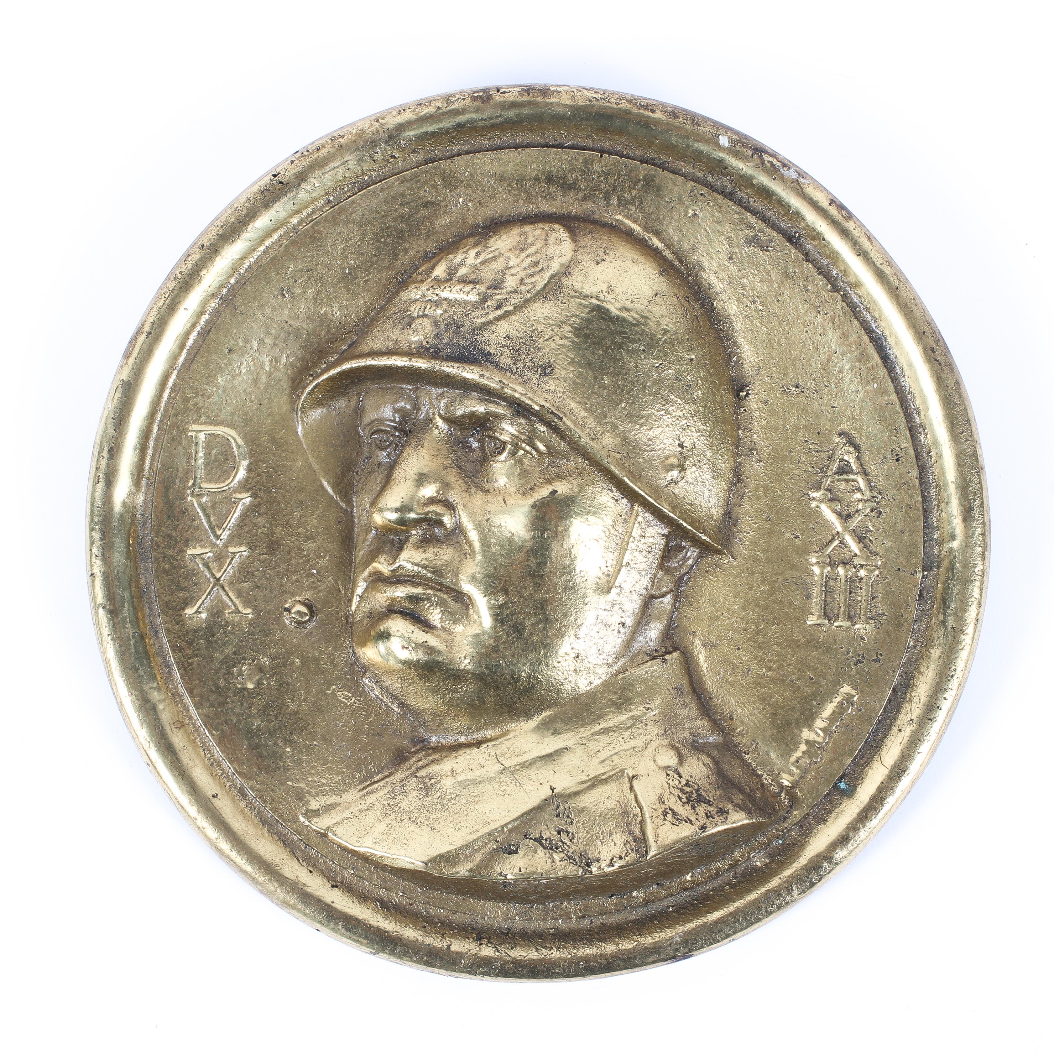 A 20th century Italian Fascist gilt brass plaque with Mussolini portrait, `DVX AXIII`.