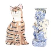 A Staffordshire pottery Delft style cat jug and a Price Kensington pottery model of a tabby cat.