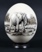 A hand painted ostrich egg, depicting an elephant cow. Signed HUGH 1996, mounted on a stand, approx.