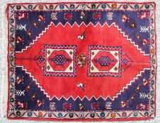 A Kordi Eastern rug with two central medalions on a red ground of geometric design with cream