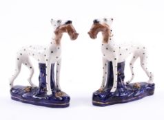 A pair of Staffordshire pottery models of greyhounds, late 19th century.