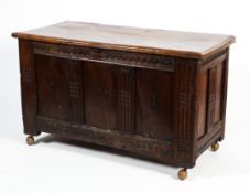 A carved oak coffer, 17th/18th century, with a plank top. The front incised with the initials A.B.H.