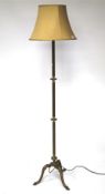 A 20th century brass standard lamp, Raised upon tripod support, with original light shade,