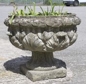 A large stone pot in the form of an urn on a square base.