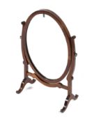 An Edwardian mahogany oval shaped dressing table swing mirror.