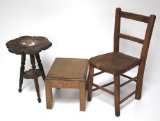 An elm seated wooden child's chair with similar footstool and a carved tripod coffee table.