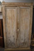 A large stripped pine kitchen pantry cupboard.