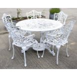 A white painted metal round garden table and five chairs with pierced decoration.