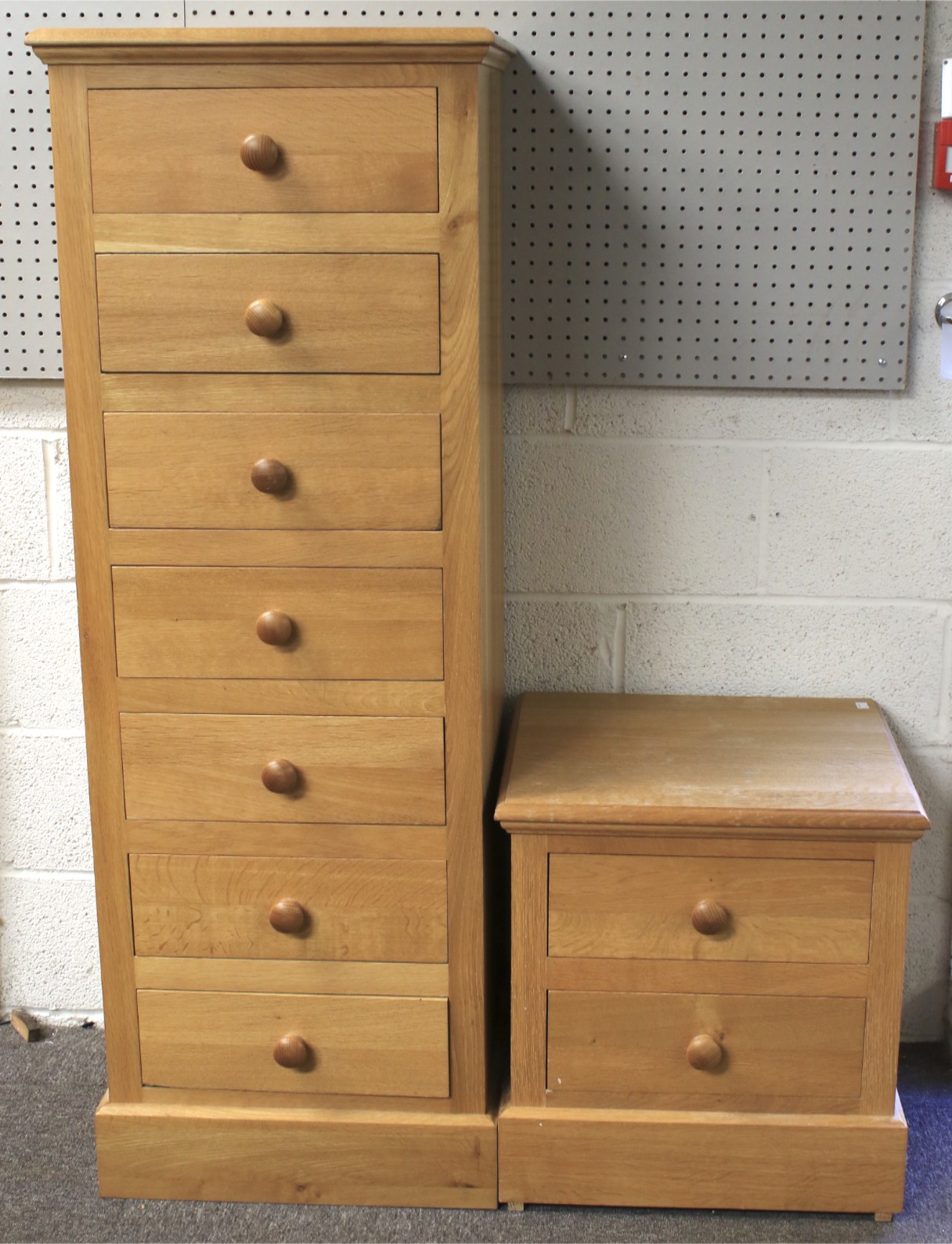 A contemporary light oak chest of drawers and a bedside cabinet.
