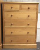 A contemporary light oak chest of drawers.