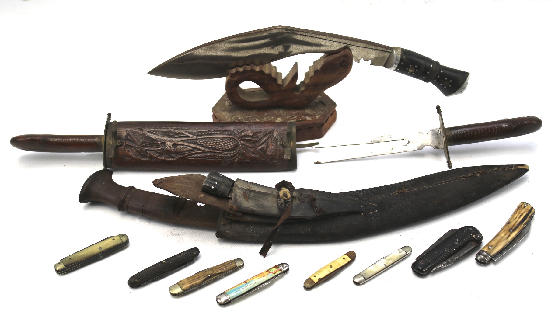 An assortment of folding knives and Middle Eastern style daggers with sheaths