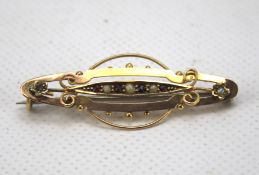 A 9ct gold bar brooch. Set with pearls and garnets and with pierced details. Weight 2.