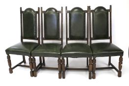 A set of four leatherette upholstered oak dining chairs.