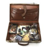 A vintage leather suitcase containing an assortment of collectables.