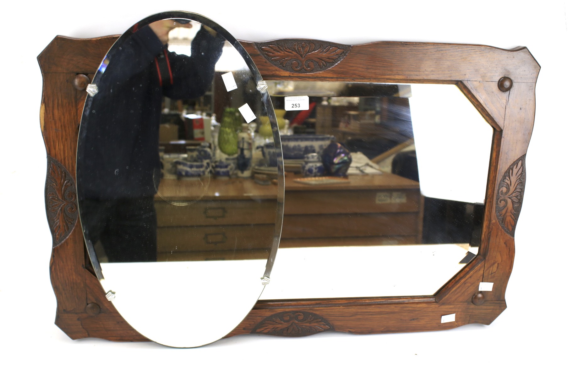 A 20th century carved wooden framed wall mirror and an oval mirror.