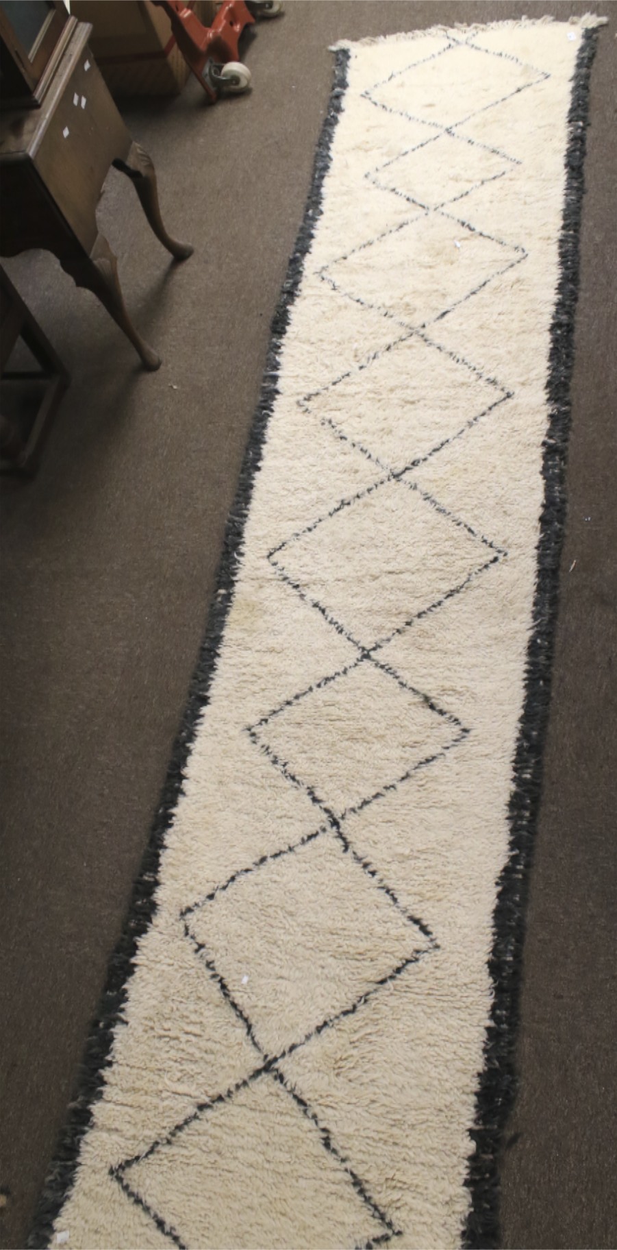 A large woollen floor runner rug.