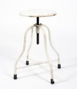 An industrial white painted metal stool, with circular top above four legs joined by X-frame,