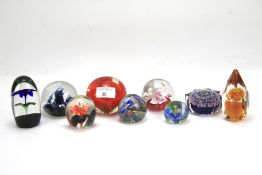 Eight assorted glass paperweights. Various sizes and designs, including Caithness and Wedgwood.