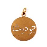 A Middle Eastern yellow metal round pendant.