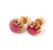 A pair of Middle Eastern yellow metal and ruby single stone stud earrings.