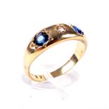 An early 20th century gold, sapphire and diamond three stone gypsy ring.