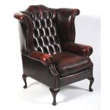 A Georgian style button back wing armchair.