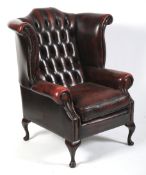 A Georgian style button back wing armchair.