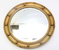 A Regency style giltwood circular mirror. With studded and reeded frame, 45 cm diam.