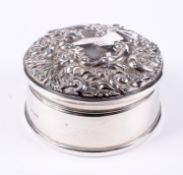 A silver circular embossed ring box.