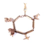 A vintage gold fancy faceted-cylinder link charm bracelet on a bolt-ring clasp with charms.